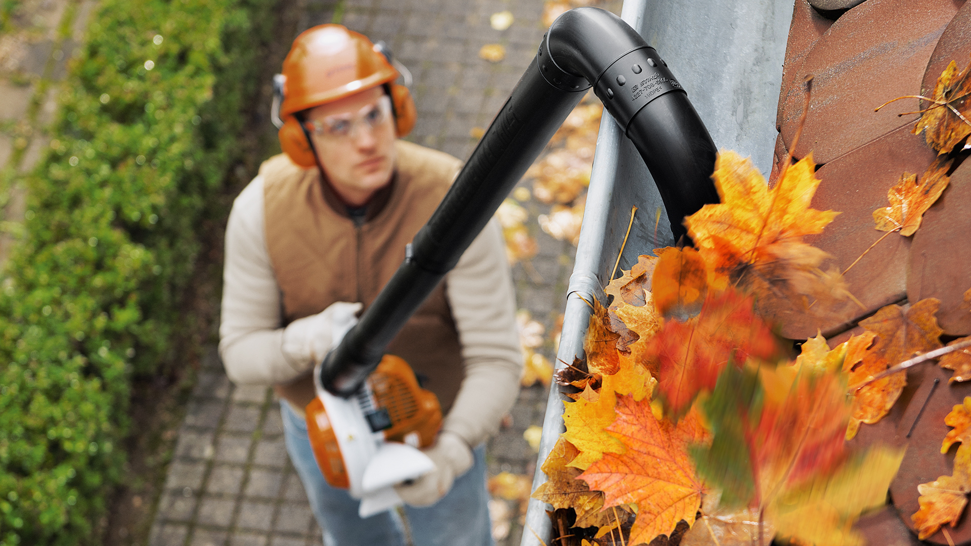 Mann med STIHL BG 56 bensinblåser renser renne  med rengjøringssett