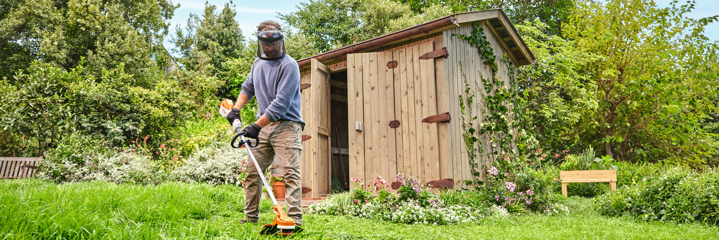  En mann klipper gress med en STIHL FSA 70 R batteridrevet ryddesag