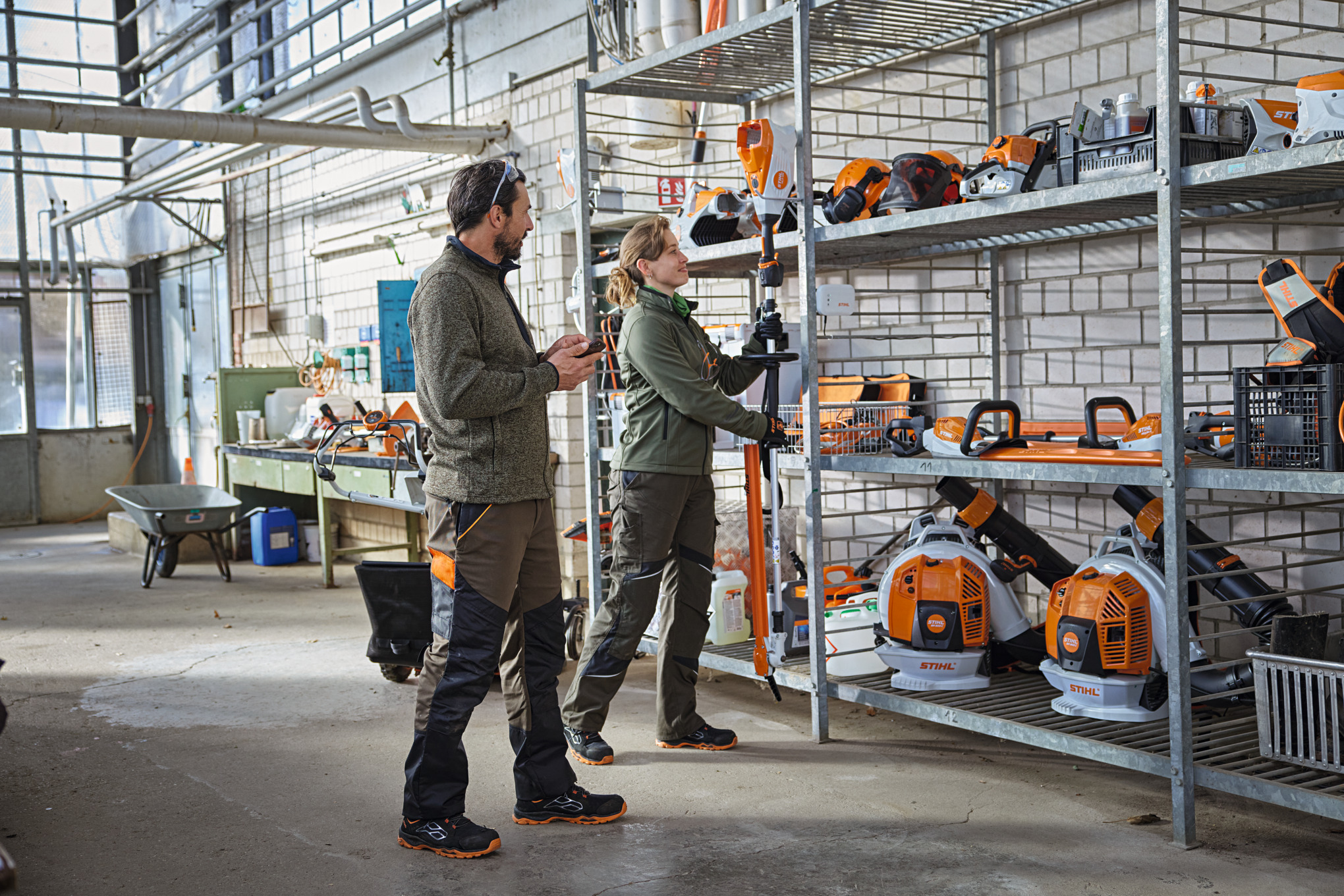 Landskapsarkitekter på et lager kontrollerer produktstatusen med STIHL Connected-appen