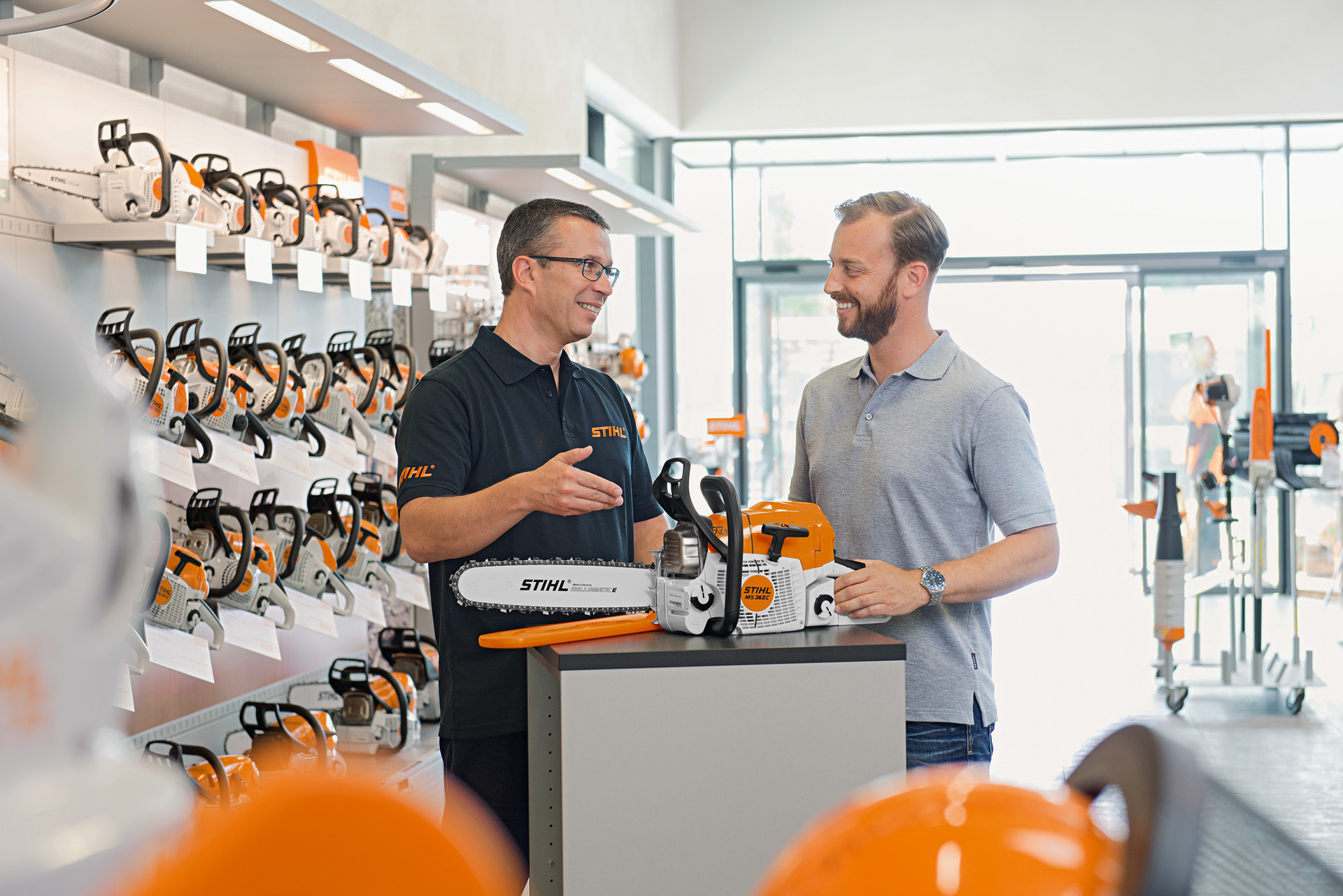 En STIHL-forhandler hjelper en kunde som kjøper en STIHL-motorsag