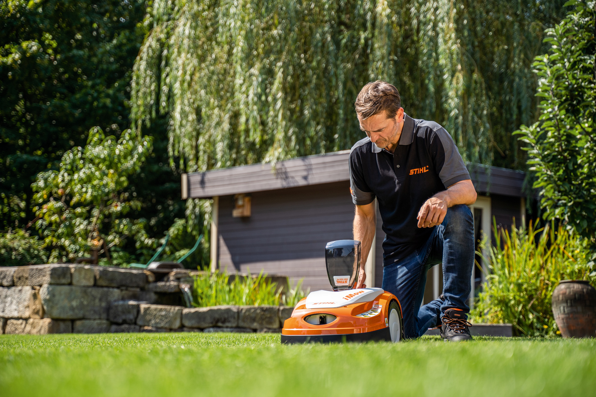 STIHL-forhandler programmerer en klippeplan for en STIHL iMOW robotgressklipper i en hage