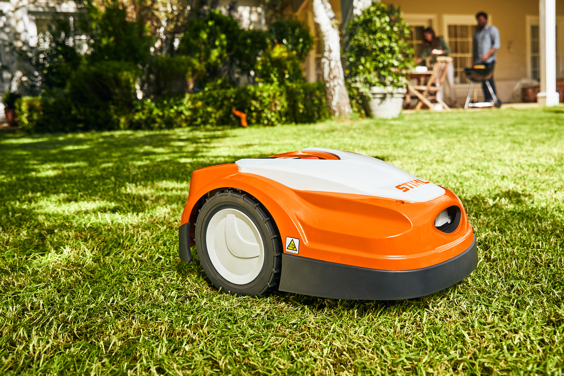STIHL iMOW® RI 422 robotgressklipper på en gressplen foran et hus